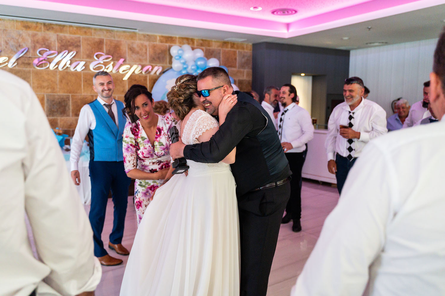 Invitado da un abrazo a la novia en su boda en Hotel Elba Estepona