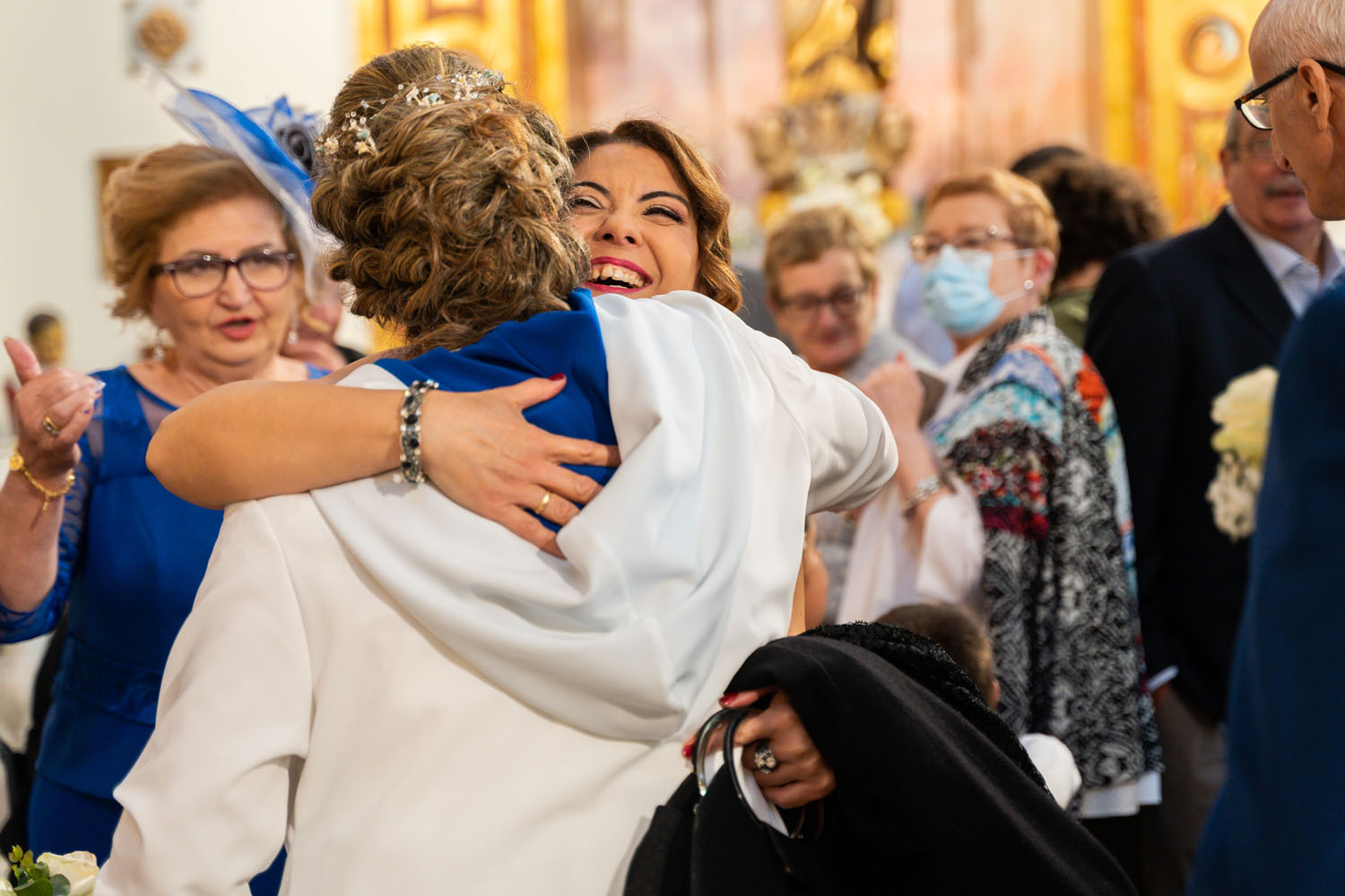 Invitados dan abrazos a los novios en su boda