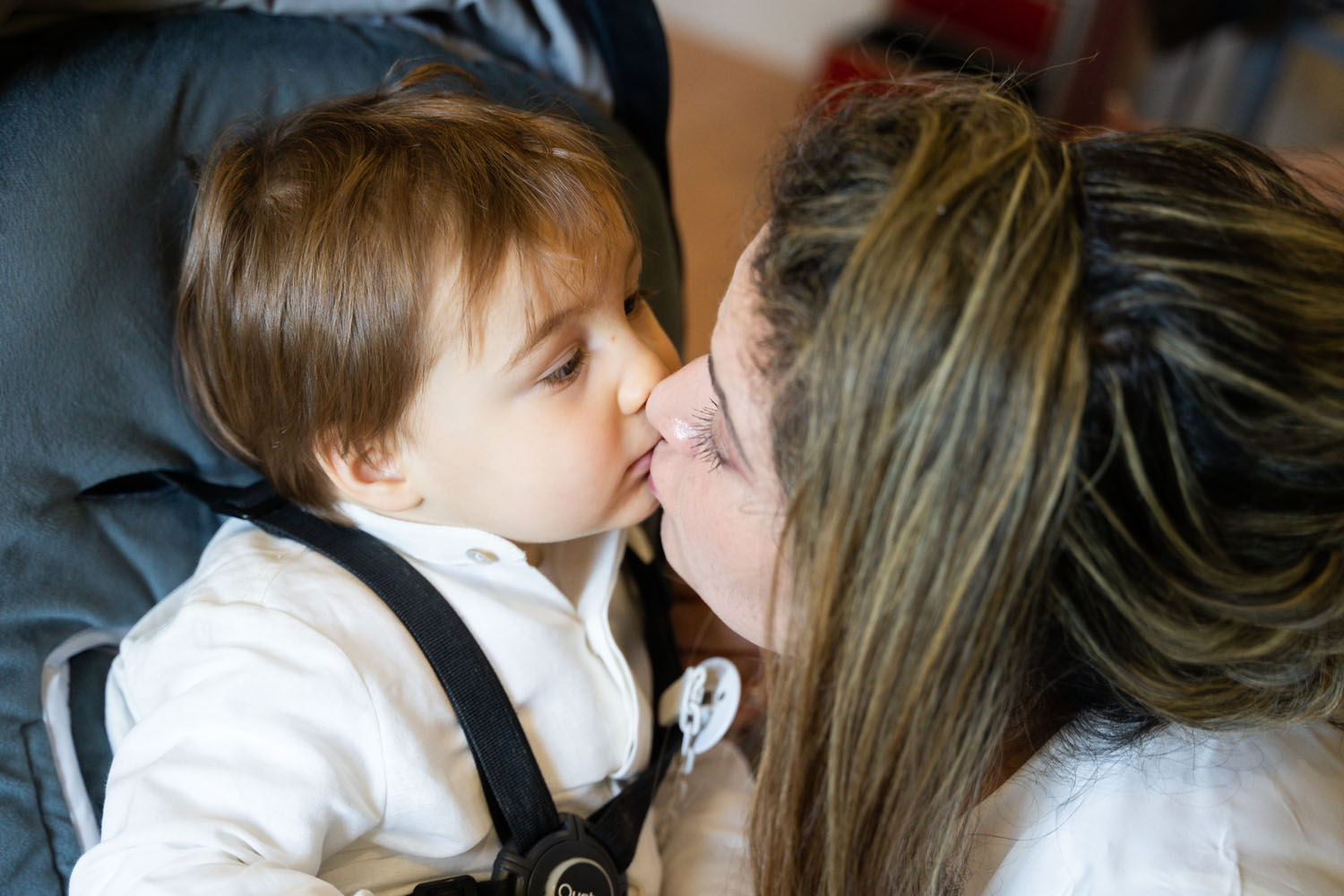 Madre le da beso a hijo en su boda