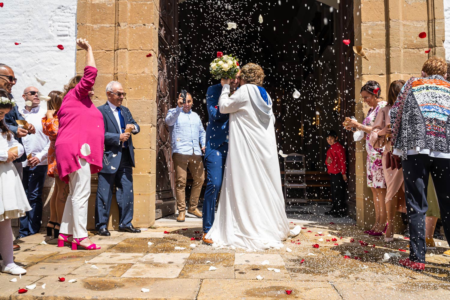 Invitados lanzan arroz a la salida de los novios, en Estepona