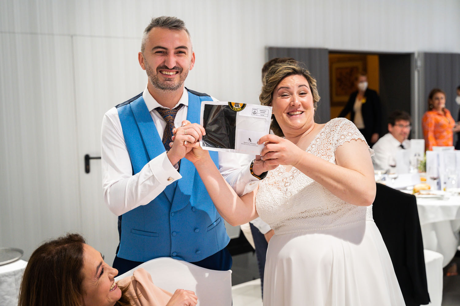 Novios posan con sobre con dinero en su boda