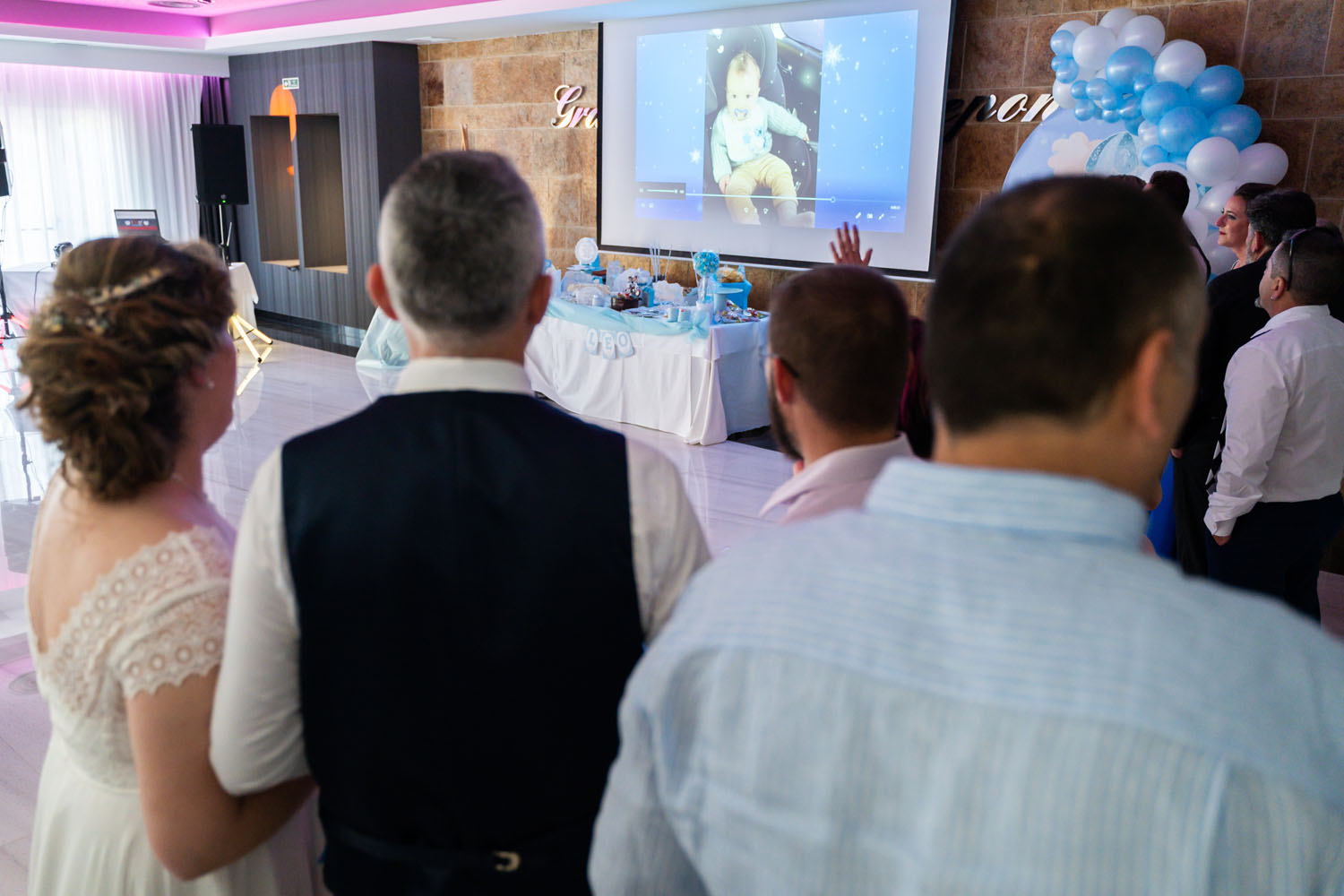 Novios viendo vídeo sorpresa con fotos durante su boda