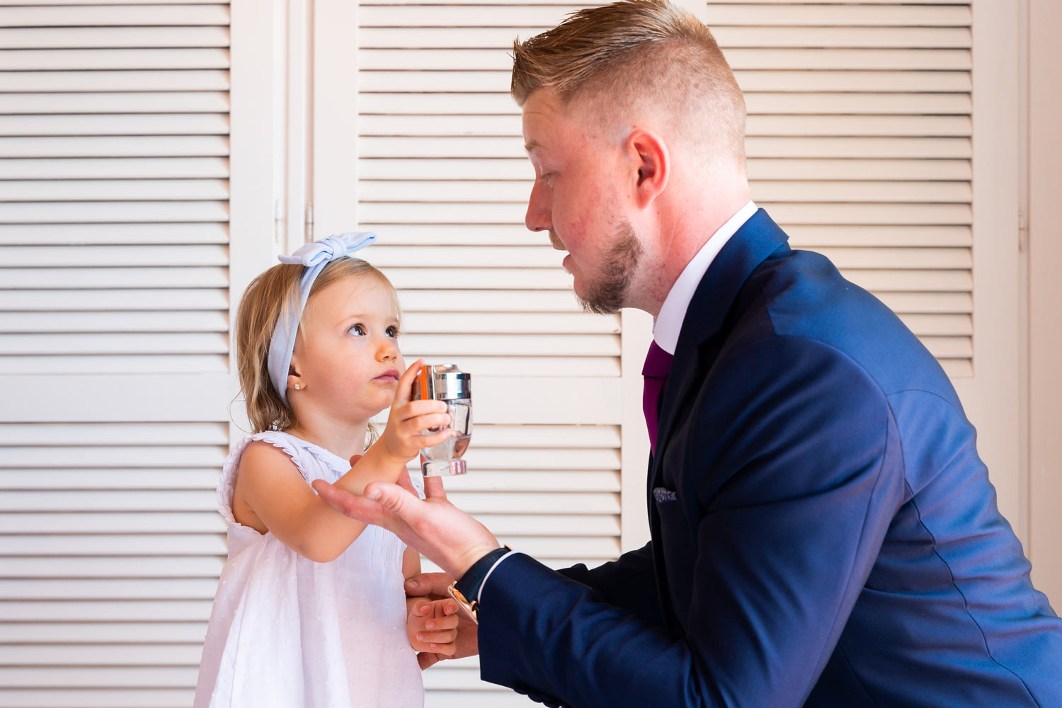 Hija pone colonia sobre su padre en su boda